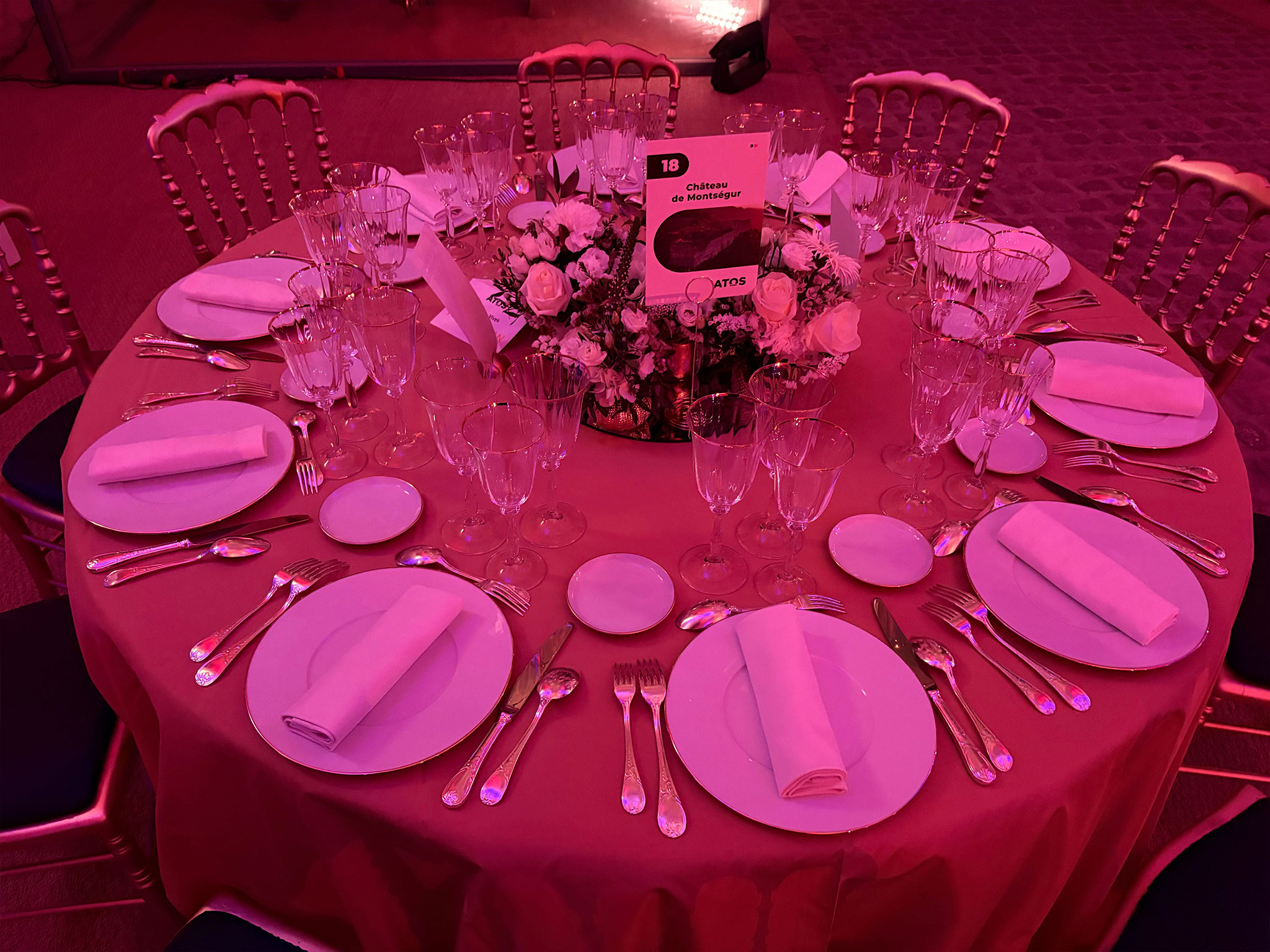 SUBLIMER LE PATRIMOINE PAR LA LUMIERE. Table dressée pour le dîner de gala Atos, éclairée en rose par la scénographie lumière d'Aucop Paris