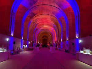 SUBLIMER LE PATRIMOINE PAR LA LUMIERE. Nef historique transformée en salle de gala avec mise en lumière bleue et orange par Aucop Paris pour Atos