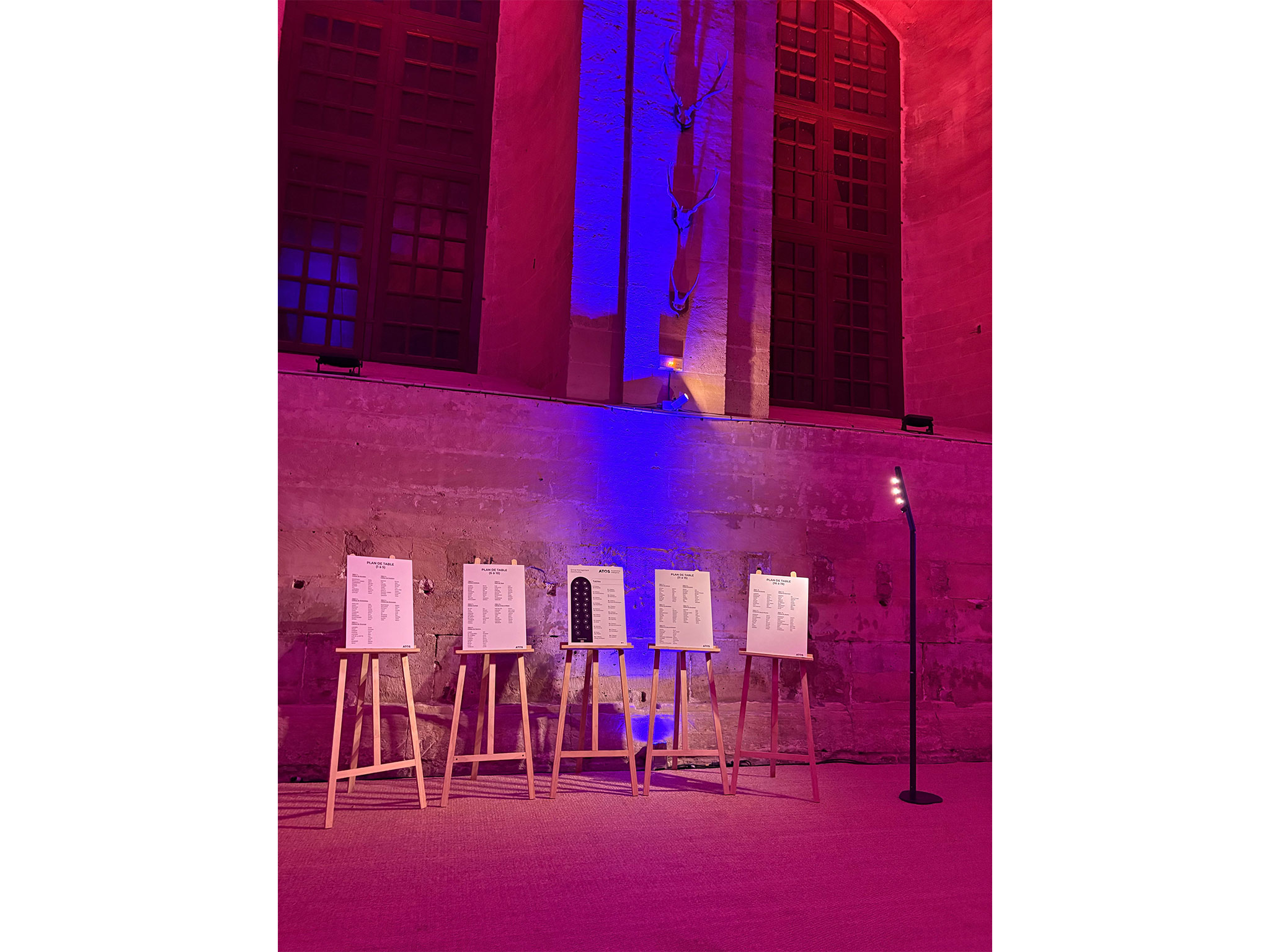 SUBLIMER LE PATRIMOINE PAR LA LUMIERE. Plans de table sur chevalets dans la nef illuminée lors du dîner de gala Atos, prestation Aucop Paris