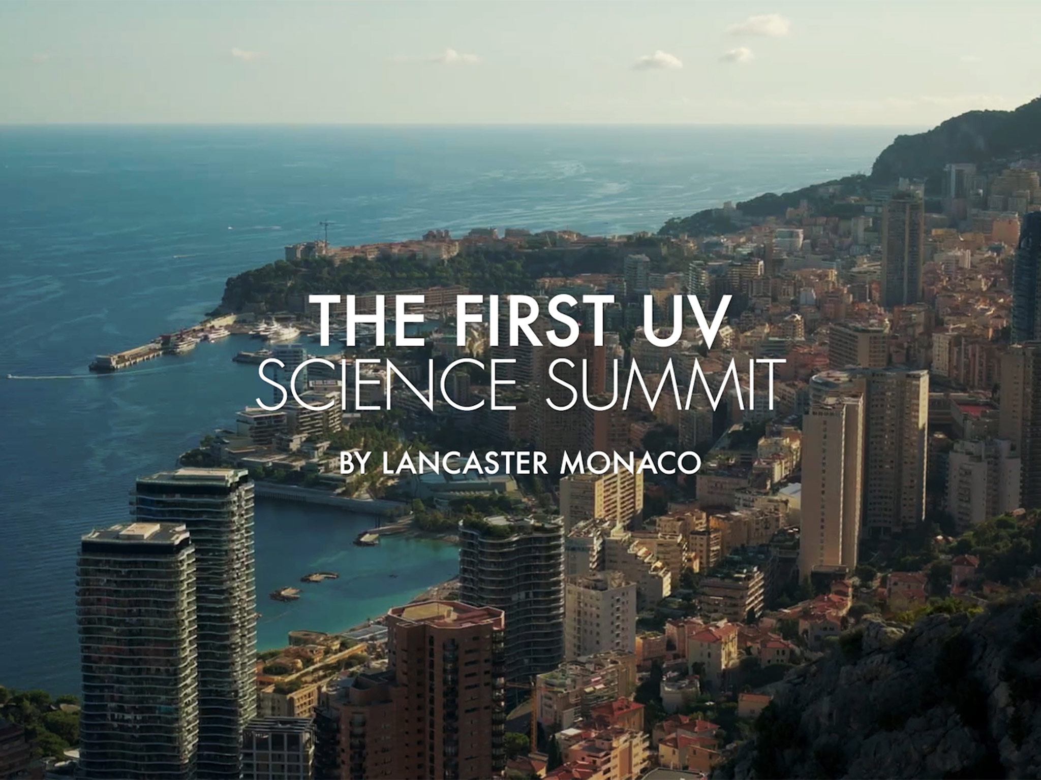 Vue aérienne de Monaco avec le titre The First UV Science Summit by Lancaster Monaco – événement scénographié par AUCOP 2026