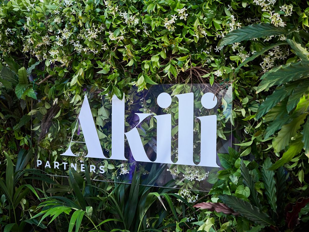 Installation du logo Akili Partners en plexiglas sur le mur végétal de la plage Croisette Beach à Cannes, mis en valeur par les spots Expo Light AUCOP lors de la soirée Akili Mirari 2026
