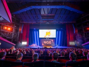 Auditorium du Palais des Festivals comble lors de la plénière NGE Ambition 2030 : fond de scène, logo NGE illuminé, vidéoprojection et mise en lumière signés AUCOP, plus de 1 000 collaborateurs en salle.