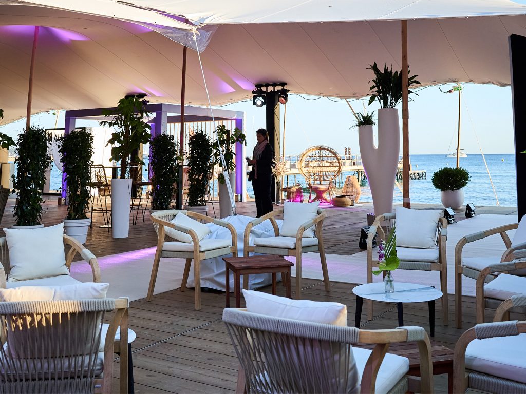 Corner immersif face à la Méditerranée : pergola fabriquée sur mesure par AUCOP avec tasseaux bois inclinés et rideaux LED, éclairée par Smart BAT lors de la soirée Akili Mirari Cannes 2026