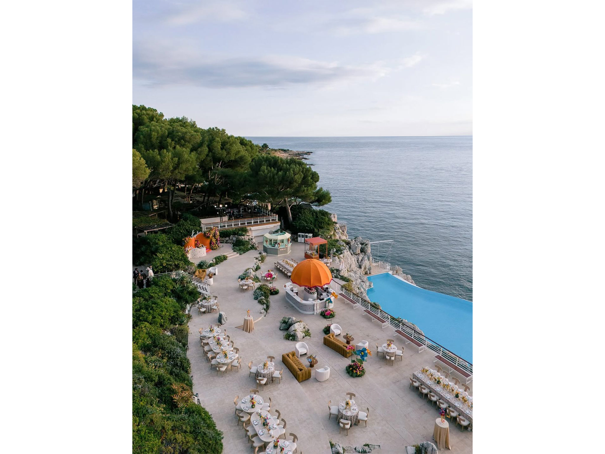 Vue générale de la terrasse du Welcome Dinner d'Angelina & Kelvin à l'Hôtel du Cap Eden Roc avec vue panoramique sur la Méditerranée, production AUCOP et White Eden Weddings.
