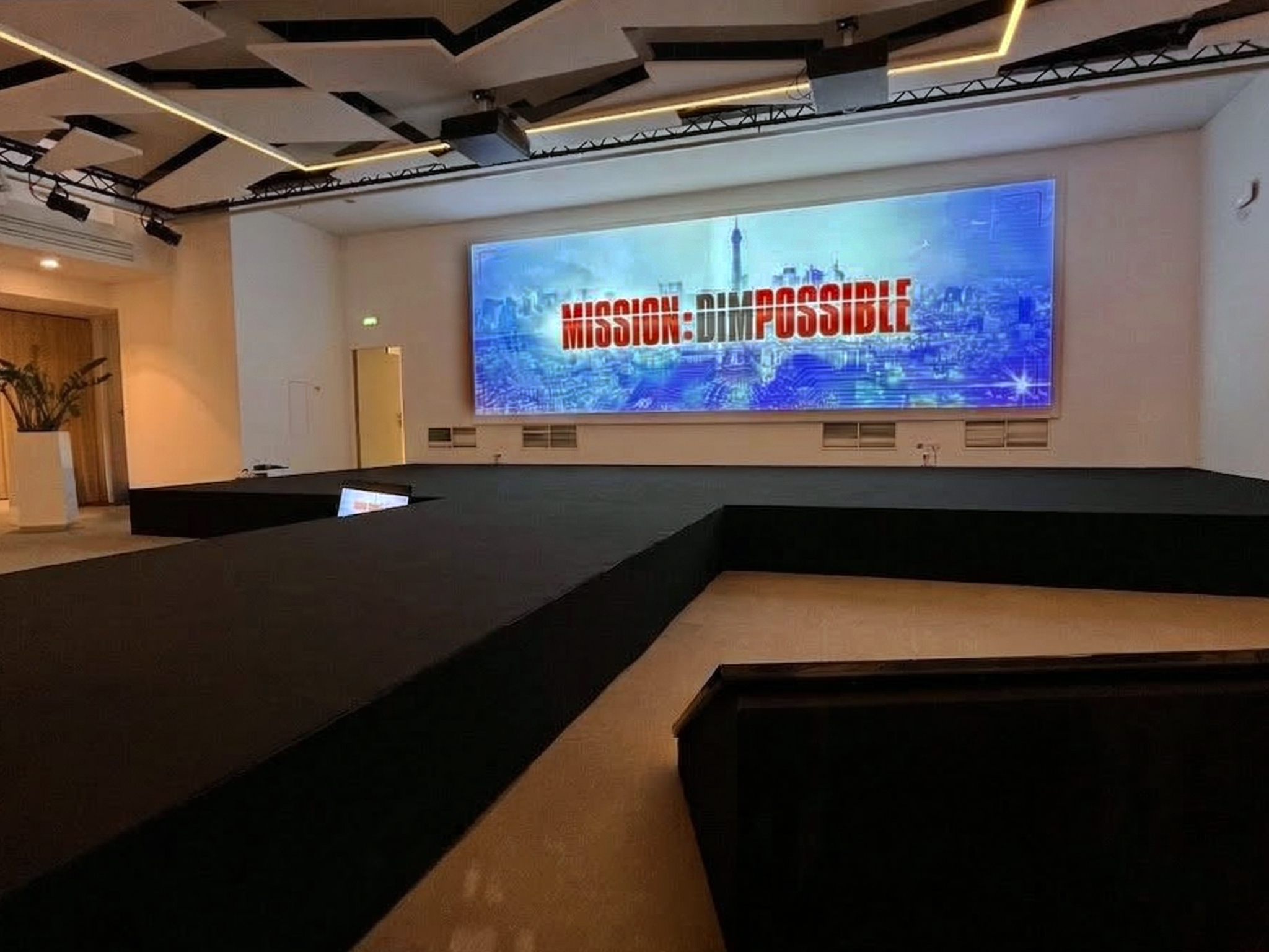 MISSION : DIMPOSSIBLE Vue d'ensemble de la salle de convention au World Trade Center Marseille Provence – installation audiovisuelle et scénographique AUCOP avec écran grand format, projecteurs asservis et chaises noires en configuration théâtre