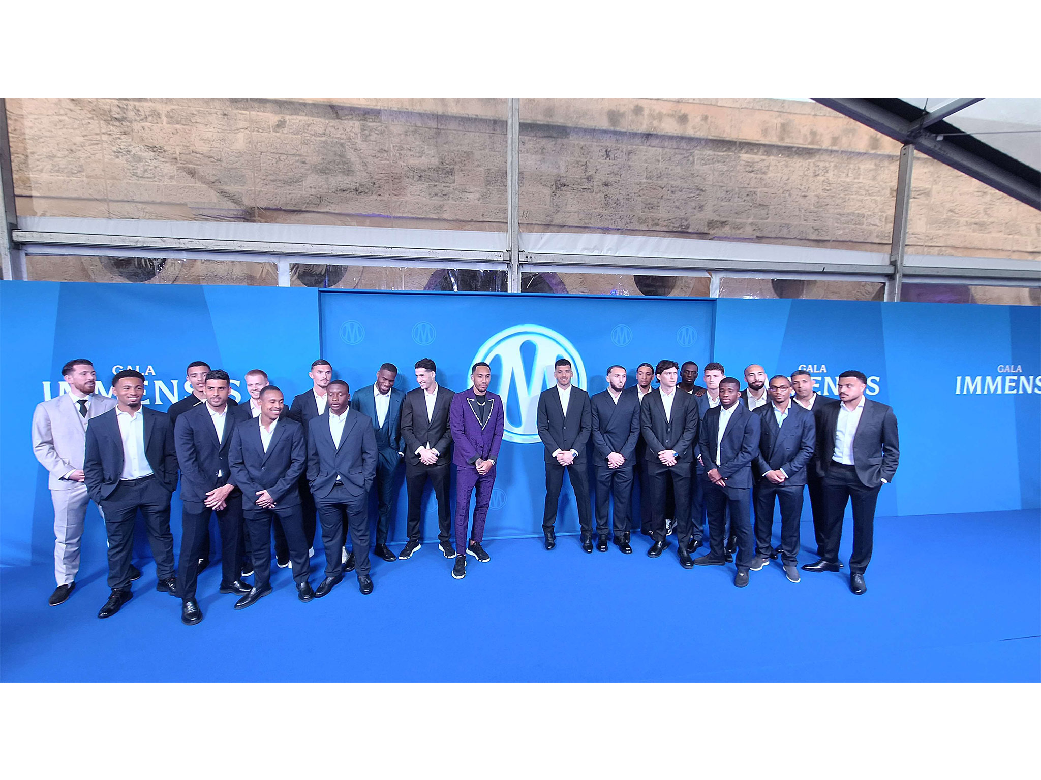 Équipe de l'OM au complet sur le photocall intérieur du Gala Immensis, devant le logo bleu de l'Olympique de Marseille