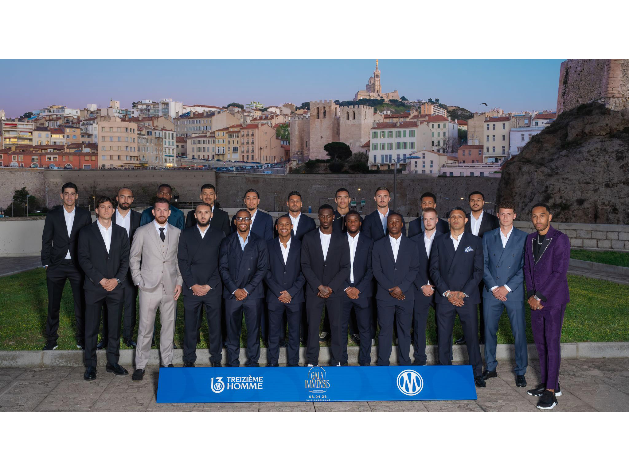 Équipe de l'OM au complet sur le photocall intérieur du Gala Immensis, devant le logo bleu de l'Olympique de Marseille