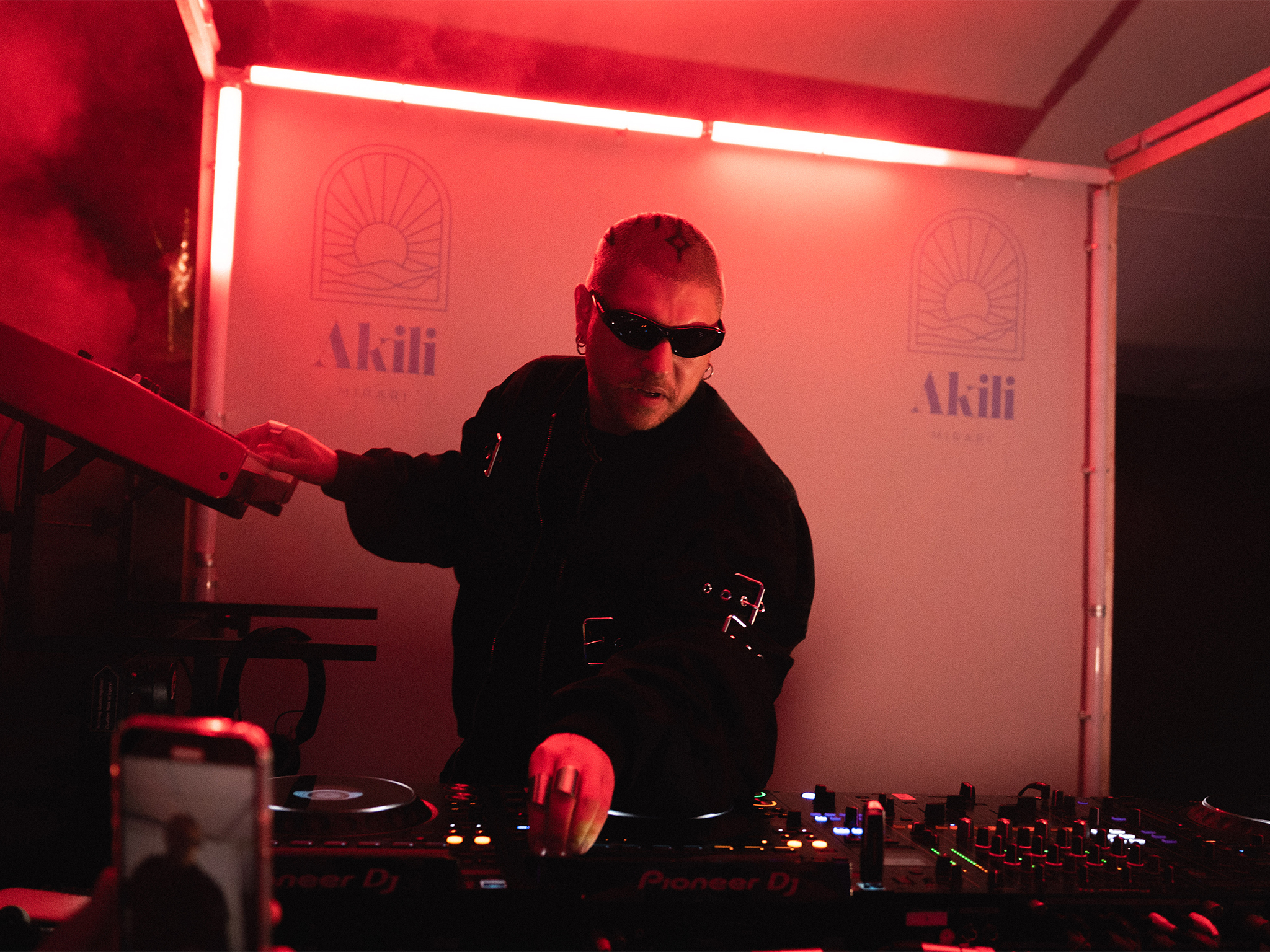 Mosimann en concert sur le DJ Booth cube AUCOP lors de l'Akili Mirari Opening Party au Festival de Cannes 2026 : foule massée devant la scène, éclairage rouge Astera Titan, plage Croisette Beach
