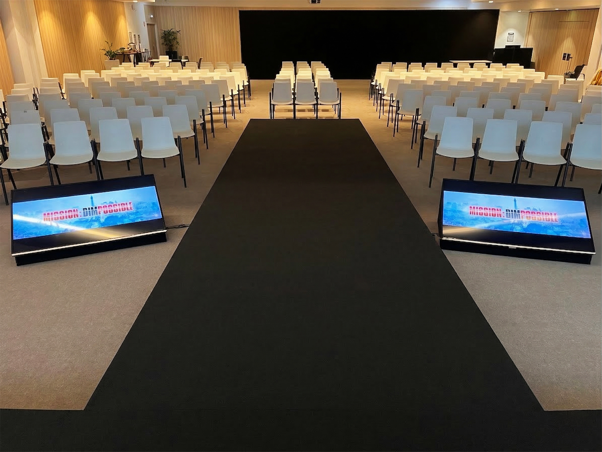 MISSION : DIMPOSSIBLE Scène habillée en moquette noire et écran de projection grand format affichant Mission DIMpossible – réalisation AUCOP pour une convention corporate à Marseille