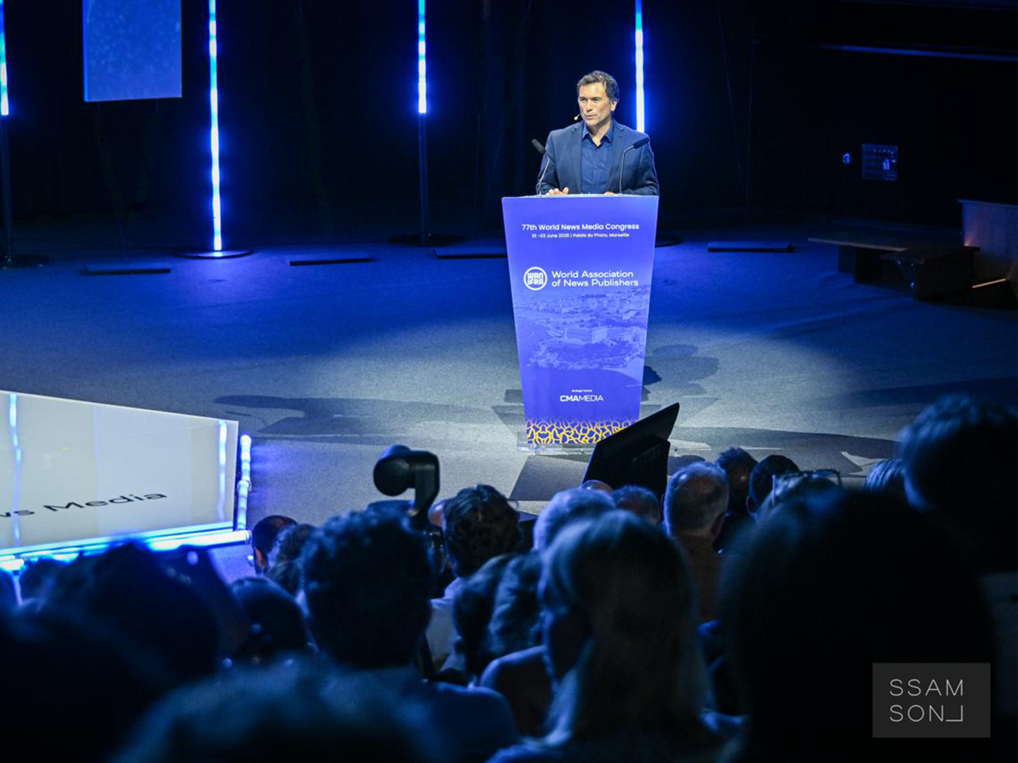 Intervenant au pupitre de l'auditorium principal du World News Media Congress, éclairage motorisé piloté en régie GrandMA3 par les équipes AUCOP.